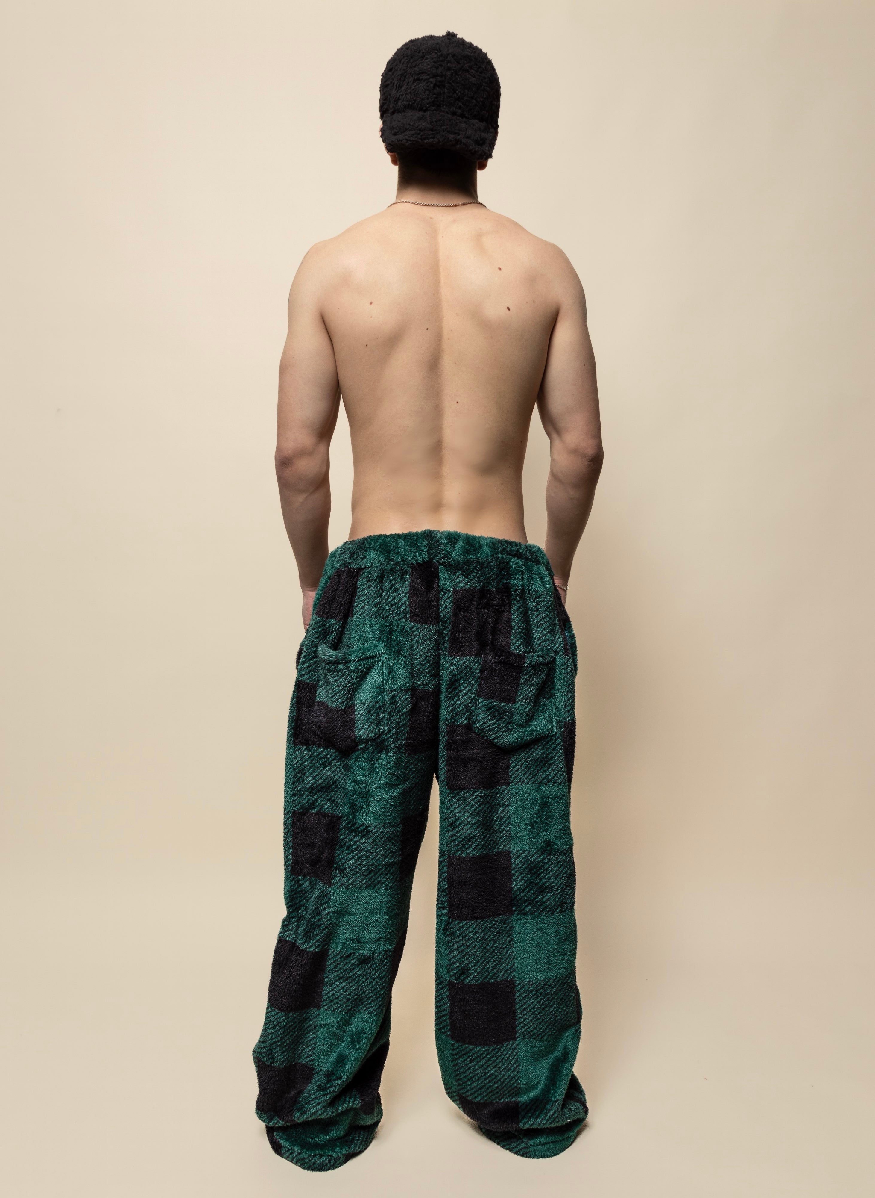 Oversized sherpa pajama pants in green checkered print. Ultra-soft faux fur, satin-lined pockets, and drawstrings for elevated lounging.